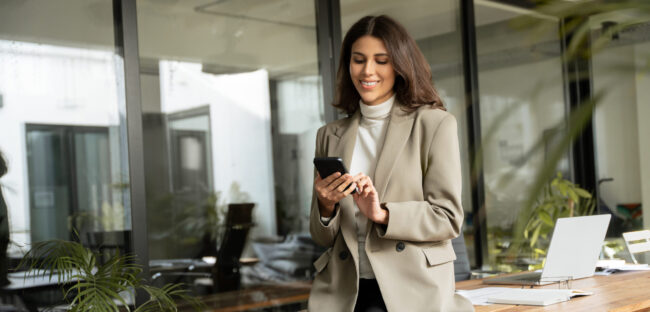 Young successful business woman manager ceo using cell phone mobile. Smiling Latin Hispanic mature female businesswoman holding smartphone in office for trading working call online. Banner, copy space